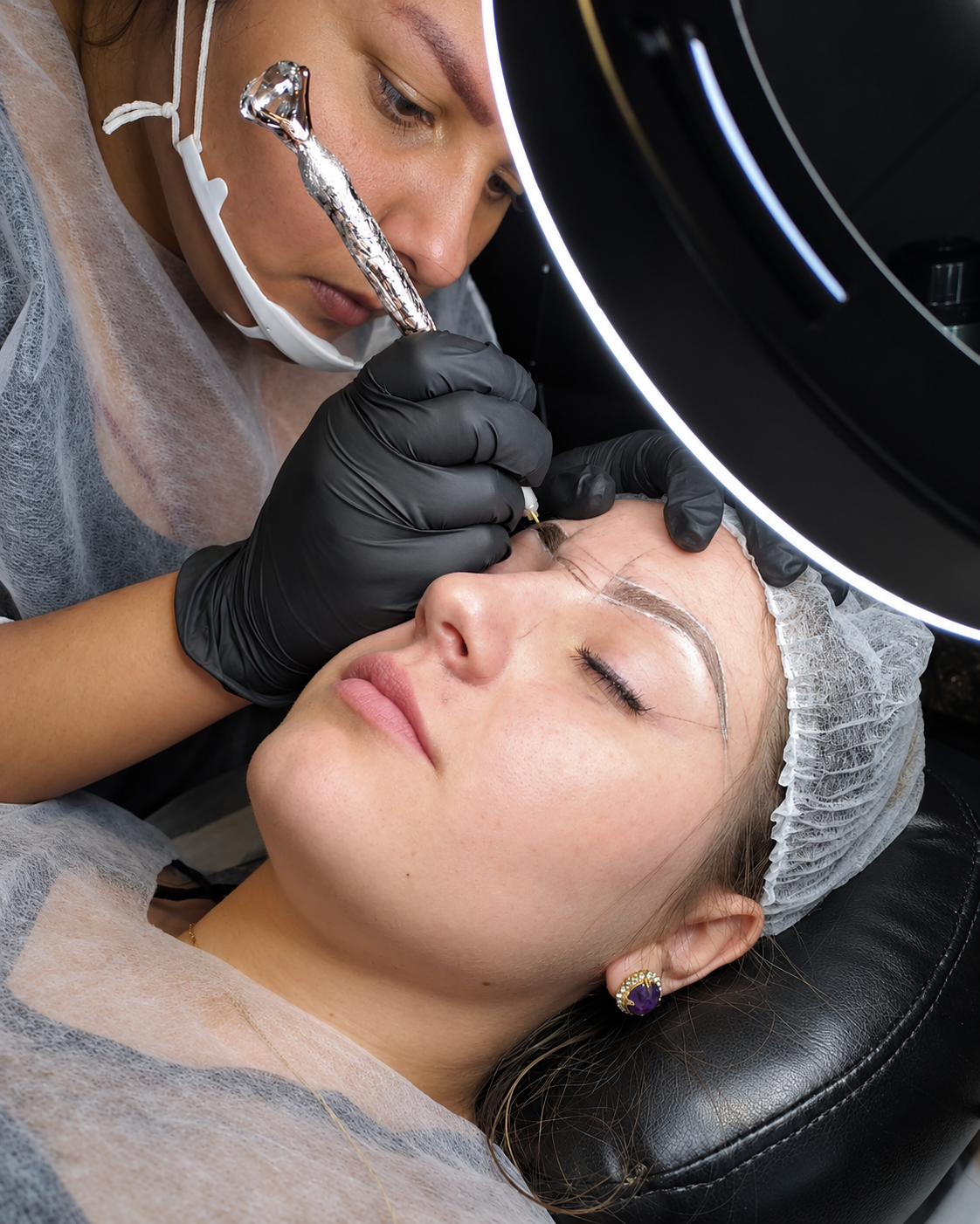 Profissional do REVELA Beauty Studio realizando um atendimento de sobrancelhas